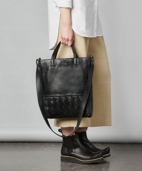 LUMI Signe Woven Tote in classic black. This minimalistic tote bag with woven textured details ticks all the boxes for a perfect day bag. Signe Tote fits a 13″ laptop and the light padding keeps it safe