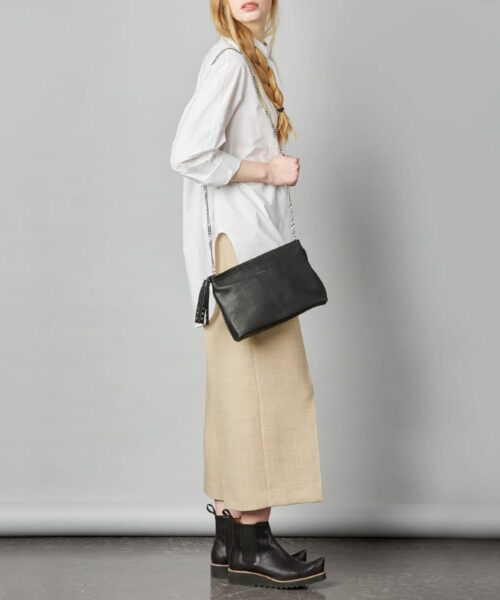 Tamara T-Bag in classy black. This roomy bag fits your phone, keys and other small essentials. It converts nicely from day to night with a long detachable chain strap, so wear it as a handbag or a clutch – what ever suits your style!